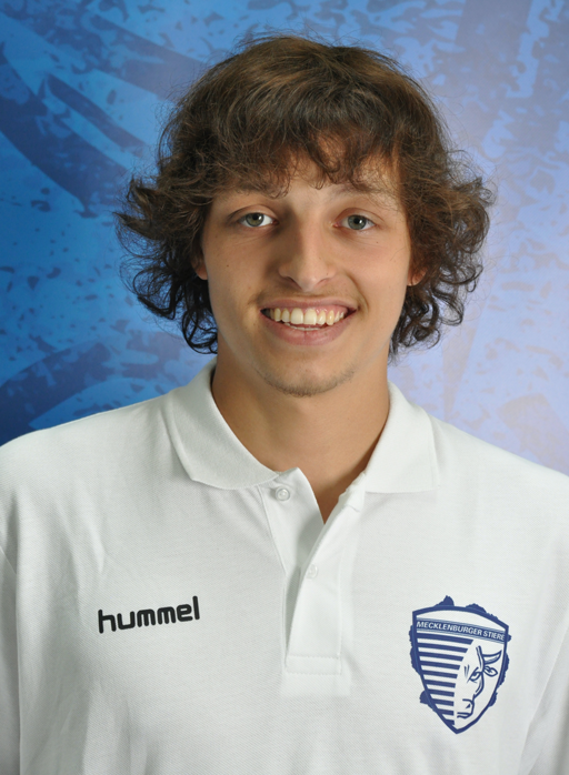 Porträt eines jungen Mannes im weißen Hummel-Polo-Shirt vor blauem Hintergrund